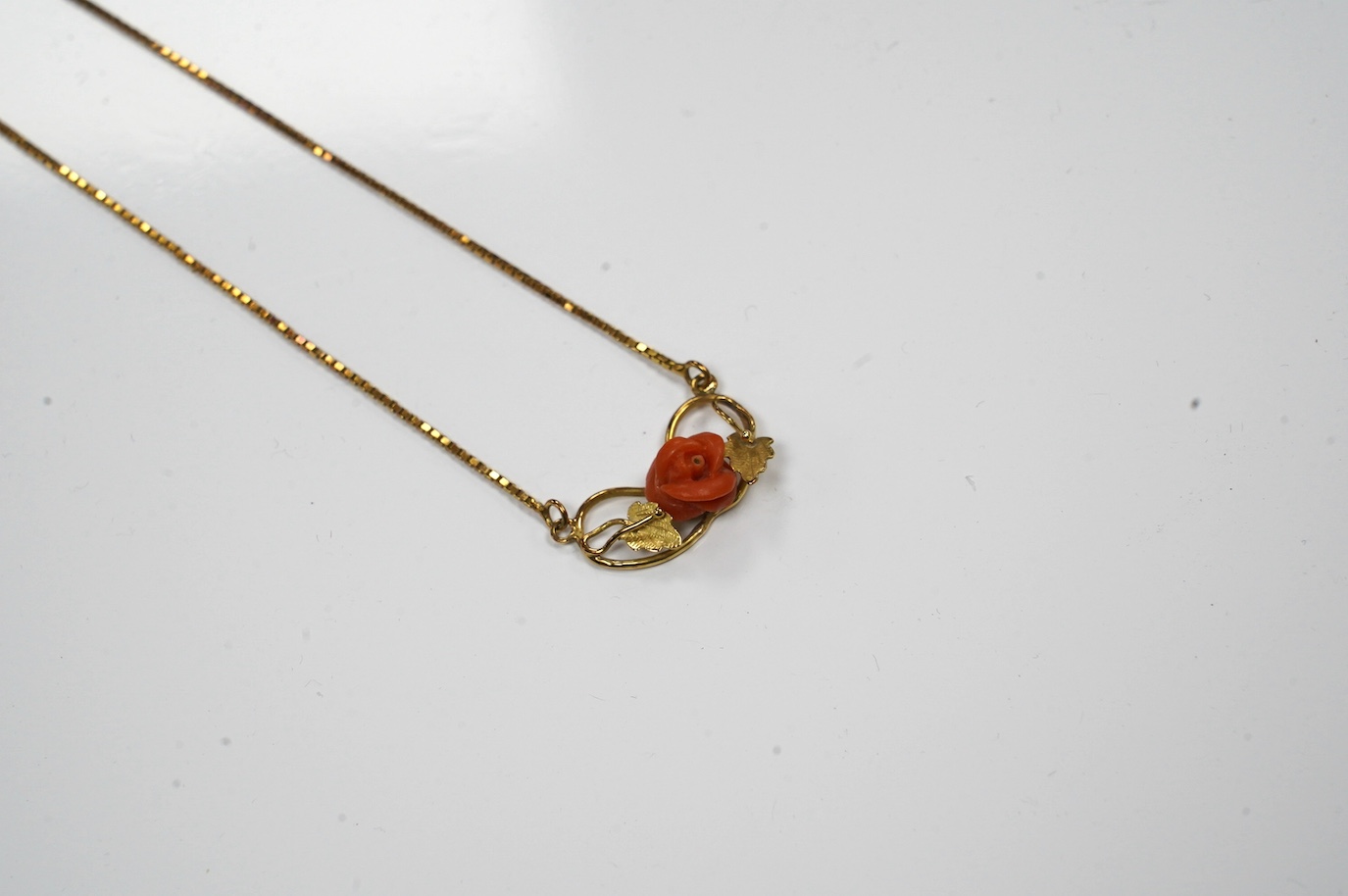 A modern Italian 18k and carved coral set pendant necklace, 40cm, gross weight 5.2 grams. Condition - fair to good